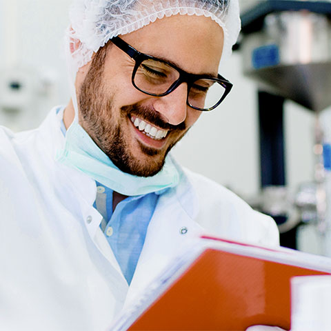 Man smiling and looking at notebook